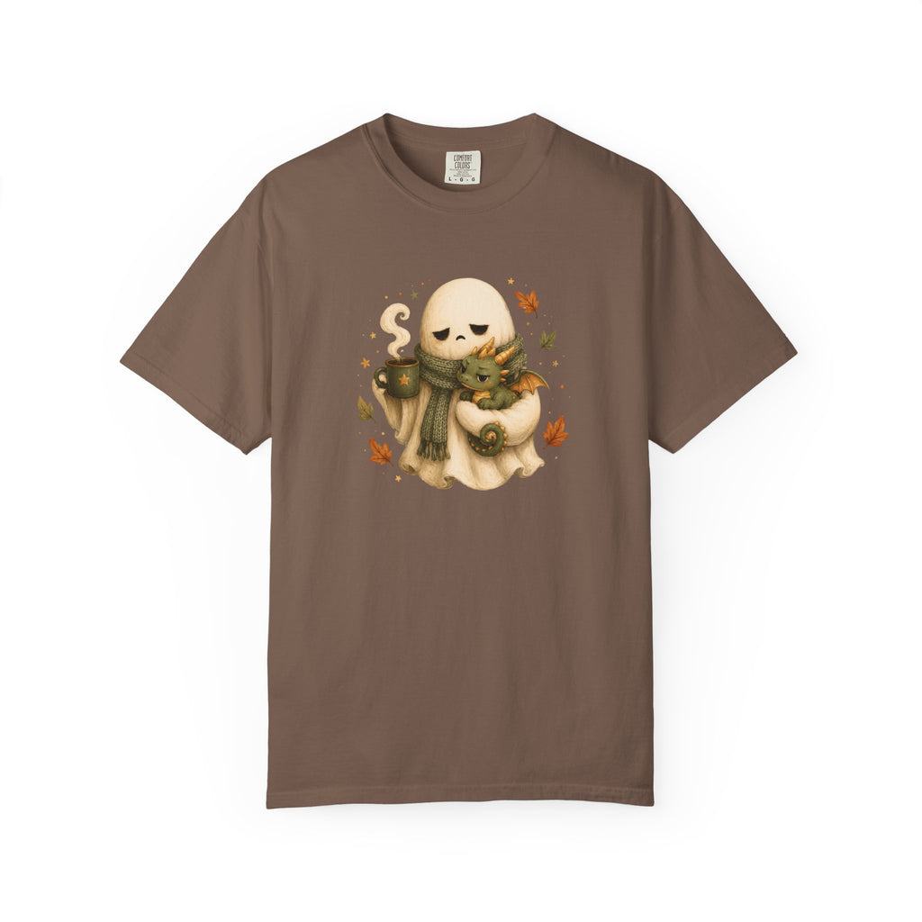 A brown short-sleeve crewneck t-shirt featuring a central graphic of a cute cartoon ghost wearing a green scarf and holding a small dragon
amidst autumn leaves.