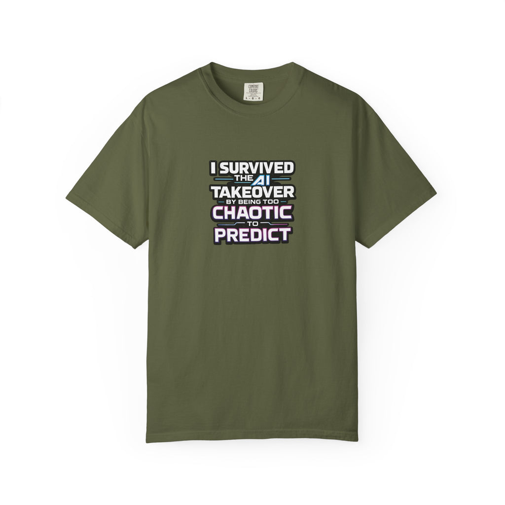 A green short-sleeve t-shirt with a graphic text print on the chest that reads 'I SURVIVED THE  AI TAKEOVER BY BEING TOO CHAOTIC OR PREDICT'. The shirt is displayed flat against a clean white background.