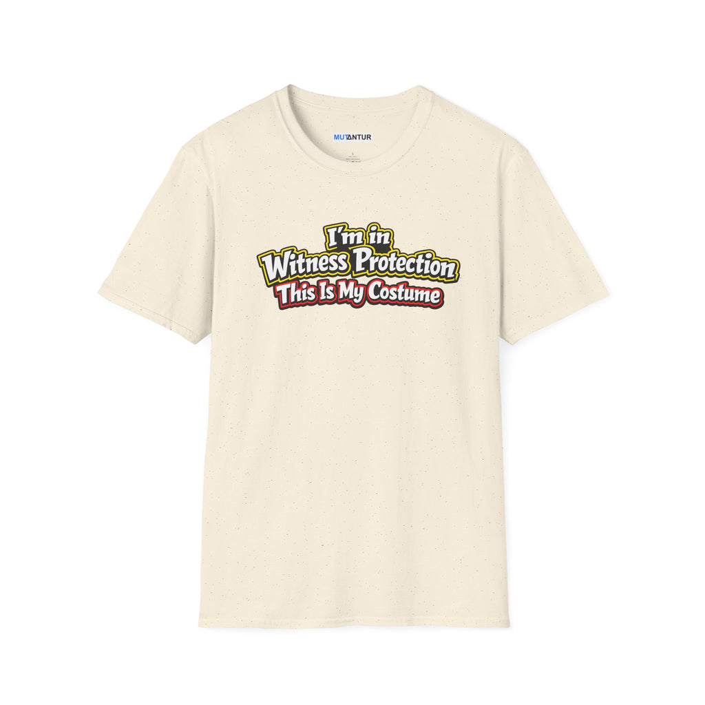 Beige short-sleeve crewneck t-shirt featuring a graphic on the chest that reads 'I'm in Witness Protection This Is My Costume' in a stylized, vintage font with green, yellow, and red accents