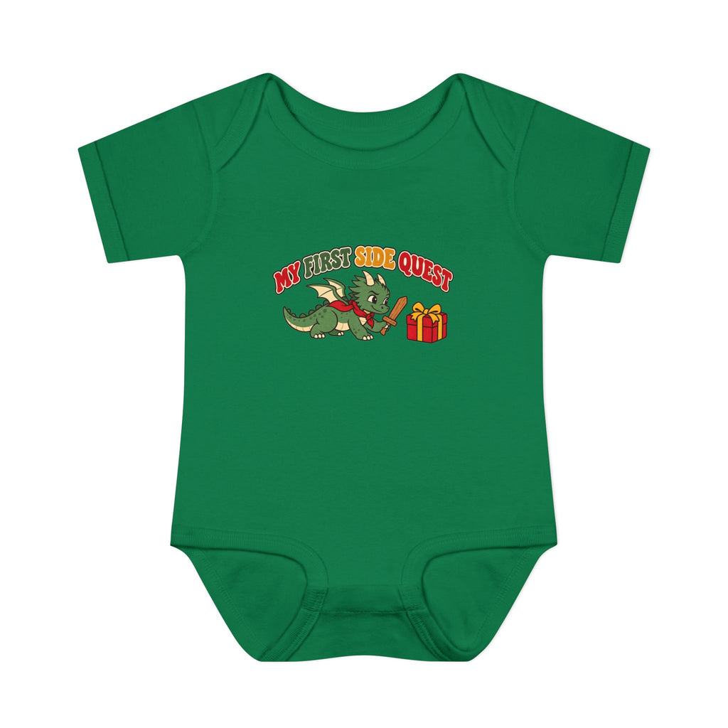 A green short-sleeve baby bodysuit with a cartoon graphic of a green dragon holding a red staff next to a red gift box, with the text 'MY FIRST SIDE QUEST' in red and yellow.