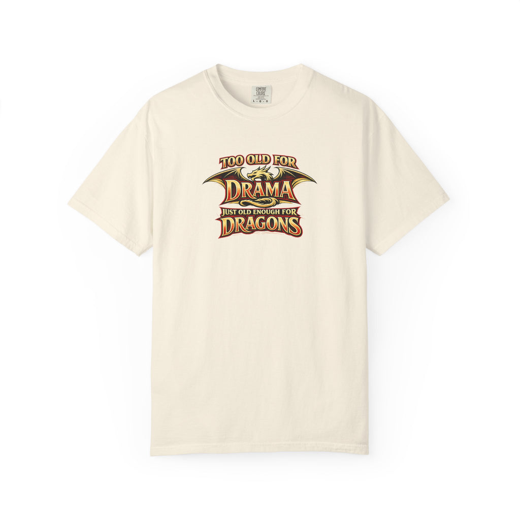 An beige short-sleeve crewneck t-shirt featuring a graphic print on the chest that reads 'TOO OLD FOR DRAMA BUT OLD ENOUGH FOR DRAGONS' in a stylized gold and black dragon-themed font.