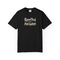 A black graphic T-shirt  that features the text 'Raised Feral Still Rolling' with a colorful 20-sided die graphic in the center against a white background