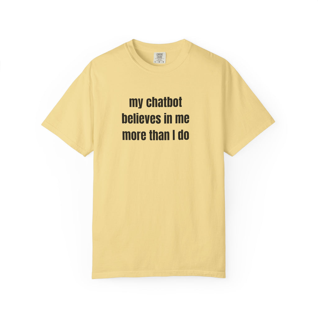 A pale yellow short-sleeve crewneck t-shirt with the text 'my chatbot believes in me more than I do' printed in black sans-serif font across the chest, displayed on a clean white background.
