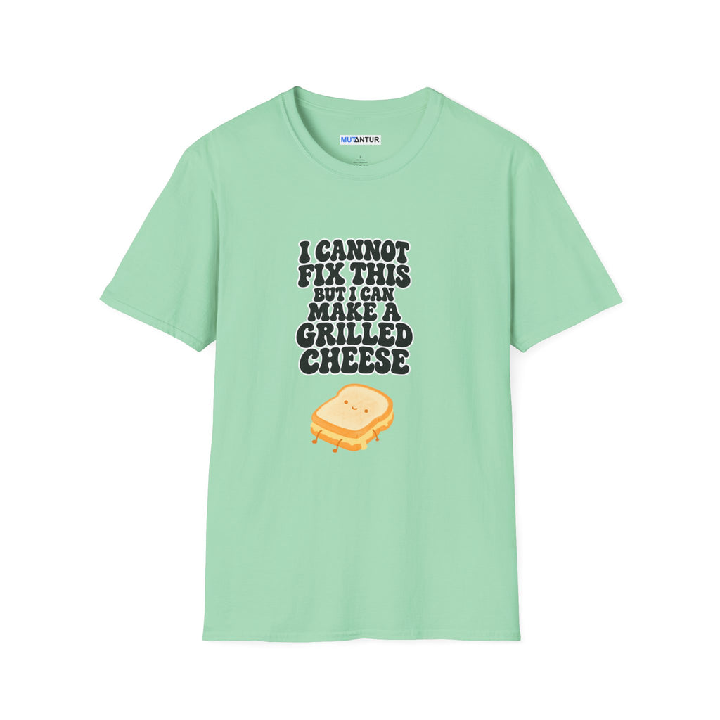 A mint green short-sleeve t-shirt with a graphic print on the front. The print features the text 'I CANNOT FIX THIS BUT I CAN MAKE A GRILLED CHEESE' in a dark gray font above a cute cartoon grilled cheese sandwich with a smiling face.