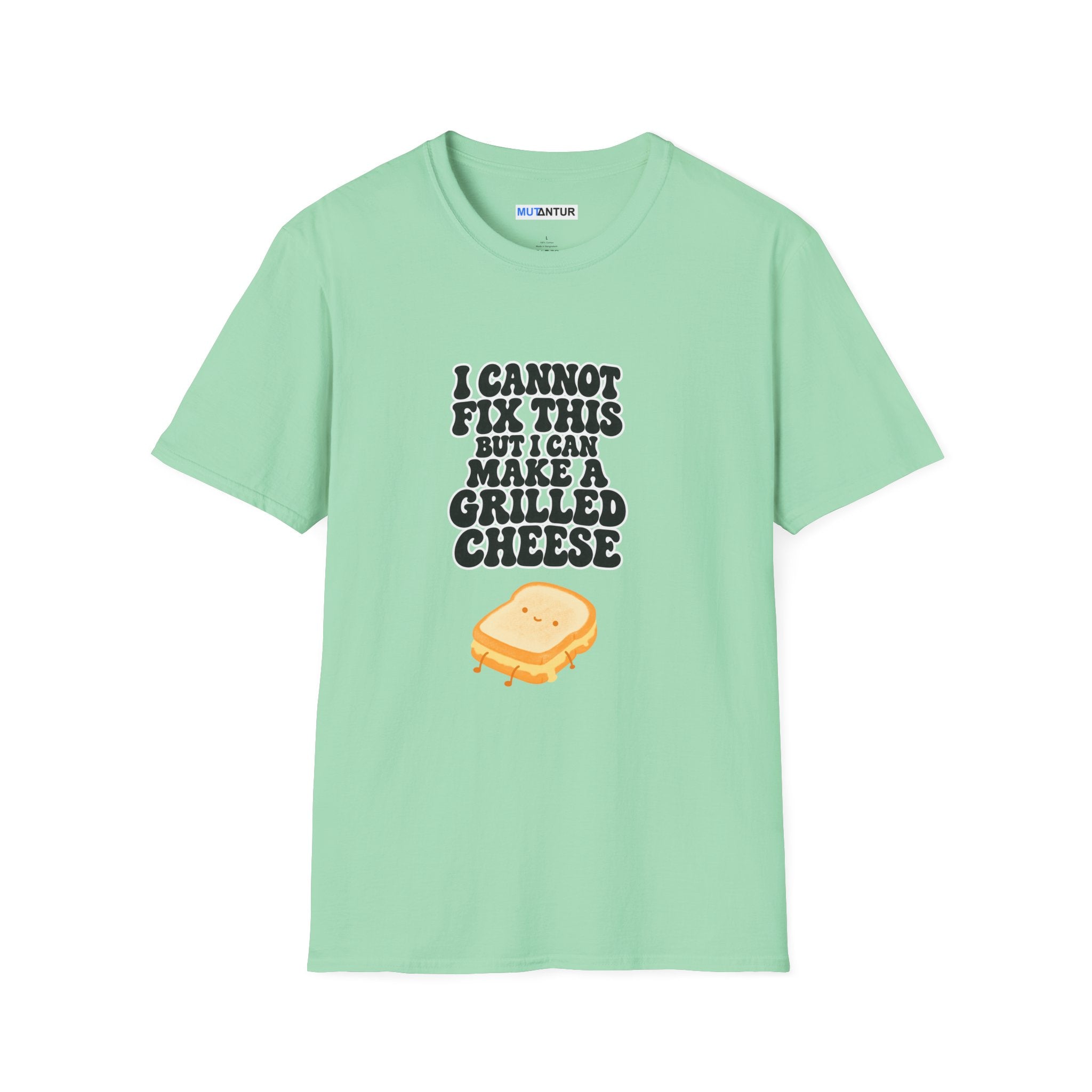 A mint green short-sleeve t-shirt with a graphic print on the front. The print features the text 'I CANNOT FIX THIS BUT I CAN MAKE A GRILLED CHEESE' in a dark gray font above a cute cartoon grilled cheese sandwich with a smiling face.