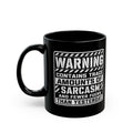 Black ceramic coffee mug printed with the warning label "Contains Trace Amounts of Sarcasm."