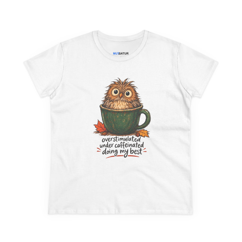 A white short-sleeve crewneck t-shirt featuring a graphic of a cute, fluffy brown owl sitting inside a green coffee mug, with the text 'overstimulated under caffeinated doing my best' written below in a handwritten font.