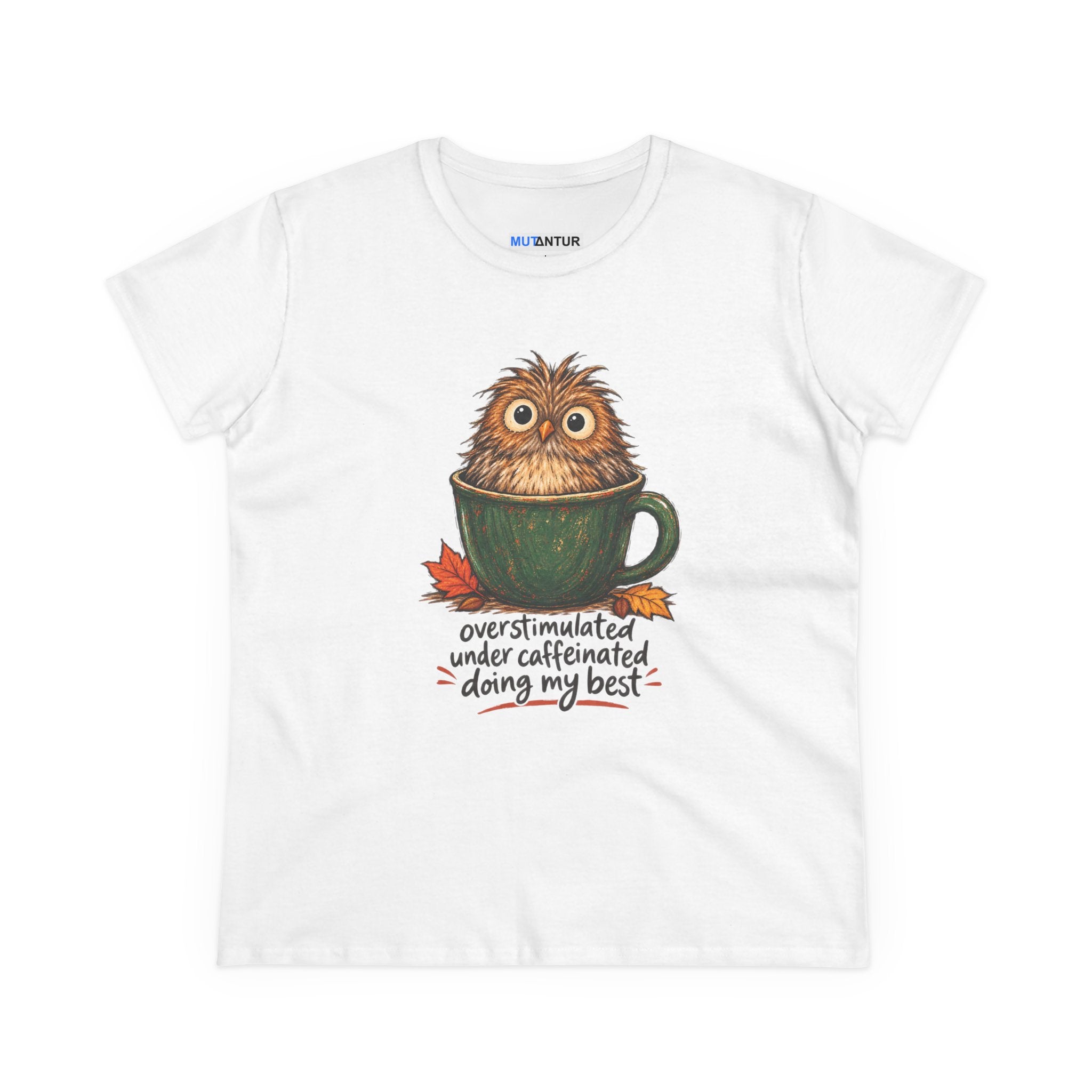A white short-sleeve crewneck t-shirt featuring a graphic of a cute, fluffy brown owl sitting inside a green coffee mug, with the text 'overstimulated under caffeinated doing my best' written below in a handwritten font.