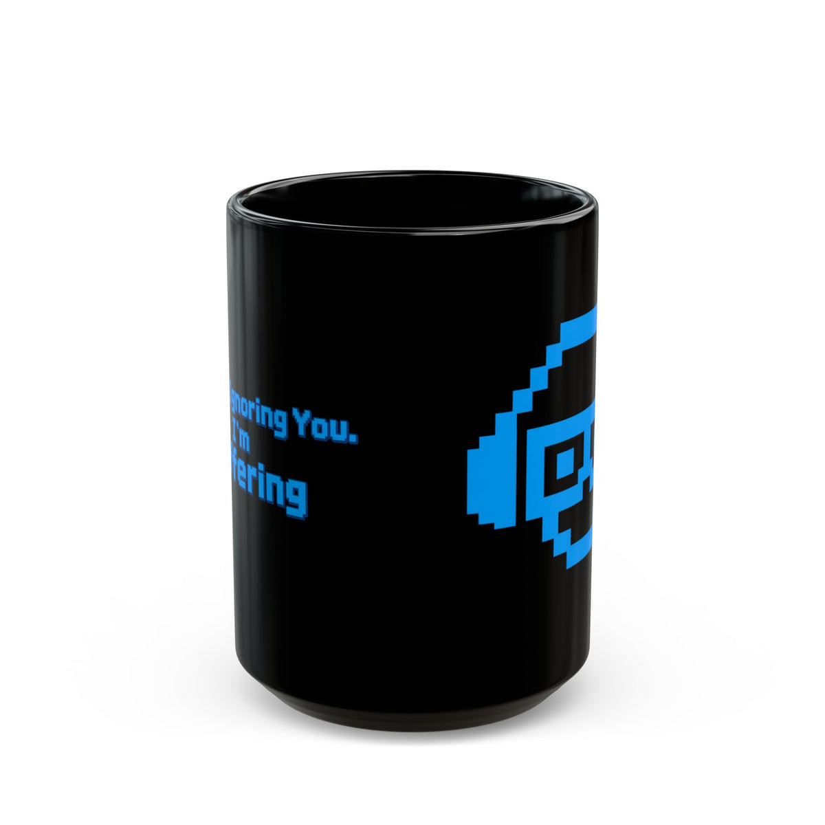 A black ceramic mug with a blue pixel face on one side and on the other side 
text that says ' I'm Not Ignoring you, I'm Buffering' against a white background