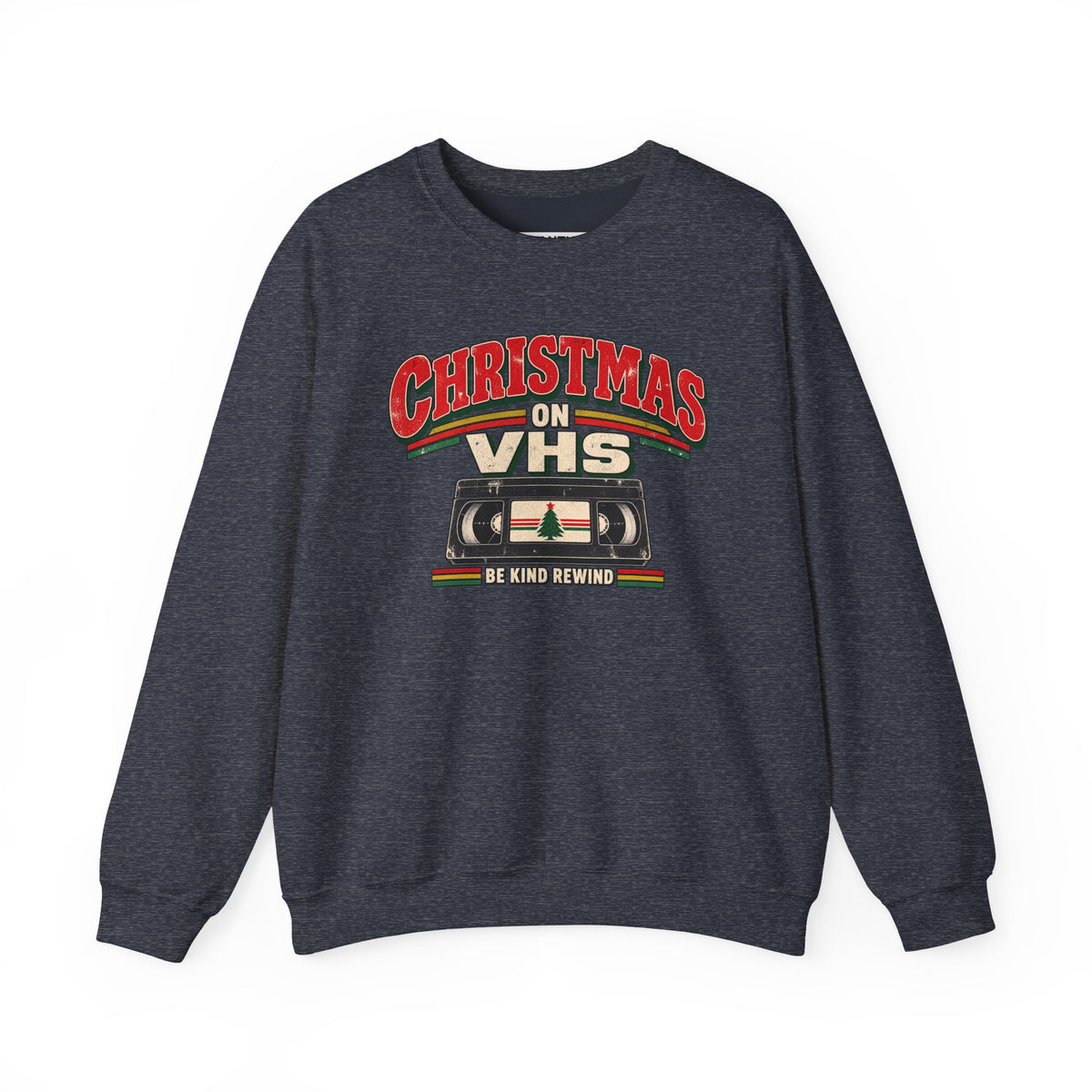 A dark heather gray crewneck sweatshirt featuring a retro Christmas graphic on the chest that reads 'CHRISTMAS ON VHS' in red and cream lettering above a cassette tape illustration, with 'BE KIND REWIND' underneath.