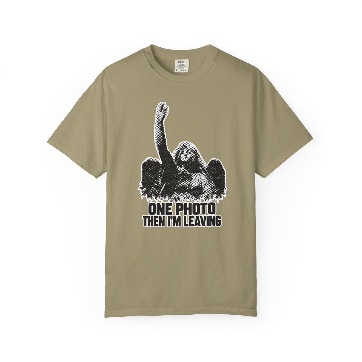 A khaki beige short-sleeve t-shirt with a black and white graphic of a winged angel figure raising its arm, above the text 'ONE PHOTO THEN I'M LEAVING'.