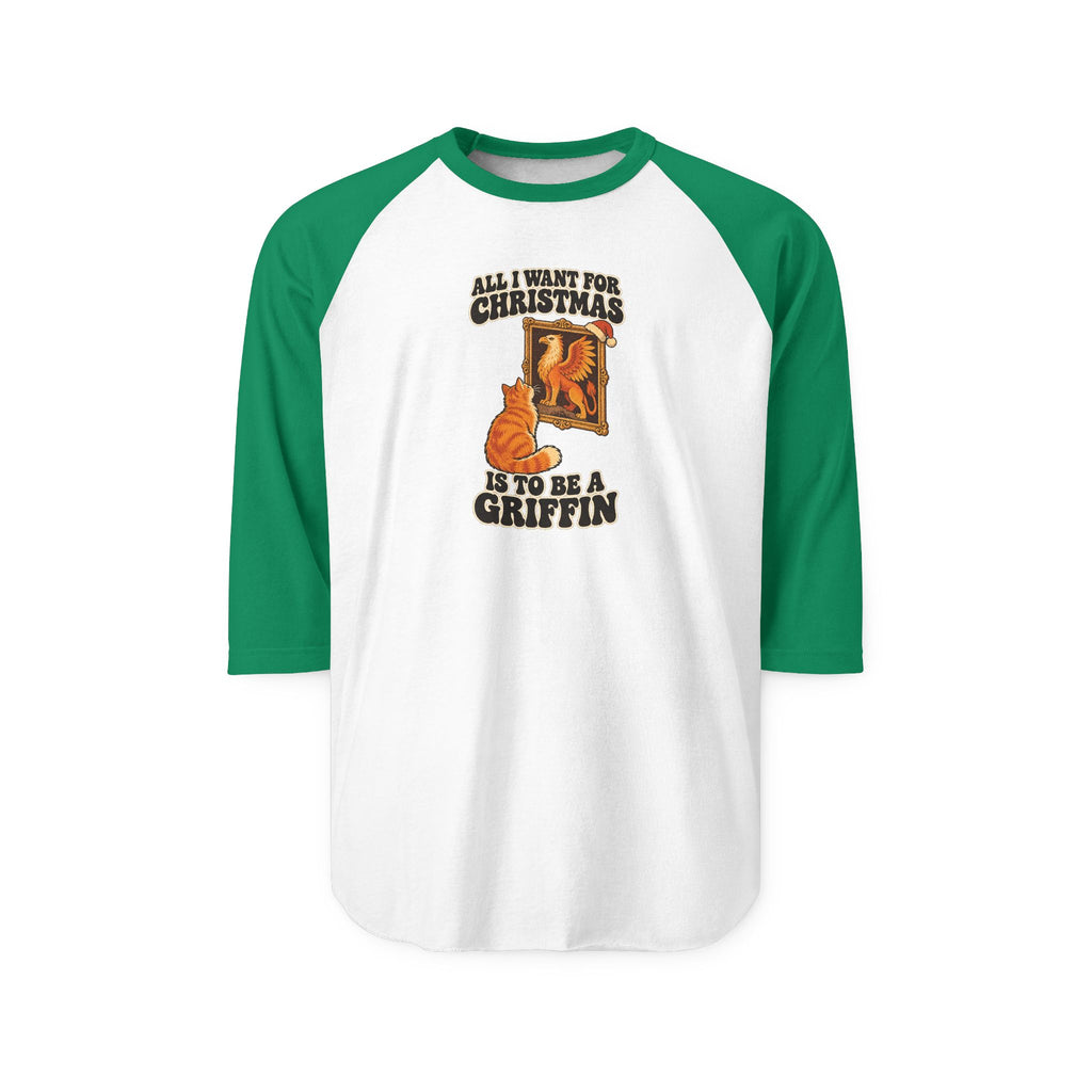 A 3/4 sleeve raglan baseball t-shirt with green sleeves and a white body, featuring a Christmas-themed graphic of an orange cat in front of a fireplace with the text 'ALL I WANT FOR CHRISTMAS IS TO BE A GRIFFIN'.