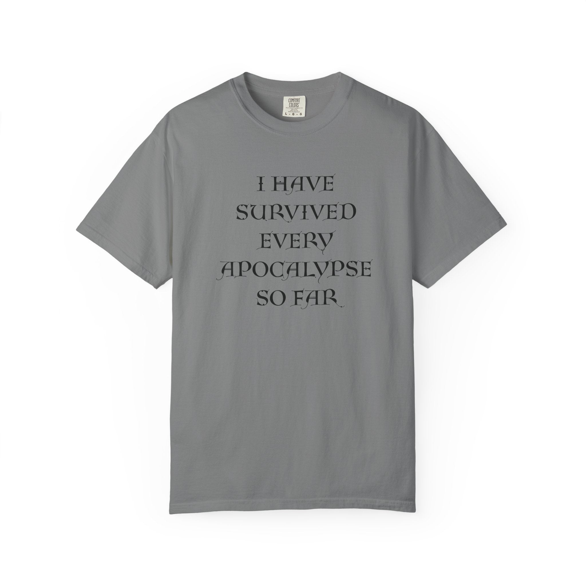 A grey short-sleeve t-shirt with black text on the front reading 'I HAVE SURVIVED EVERY APOCALYPSE SO FAR.' on a plain white background.