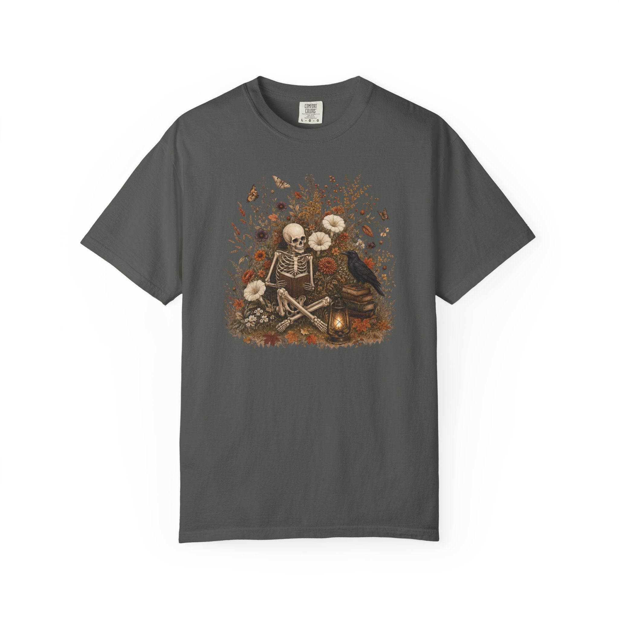 A dark gray crewneck t-shirt featuring a central graphic print of a skeleton sitting cross-legged surrounded by white flowers, a crow, and autumn leaves.