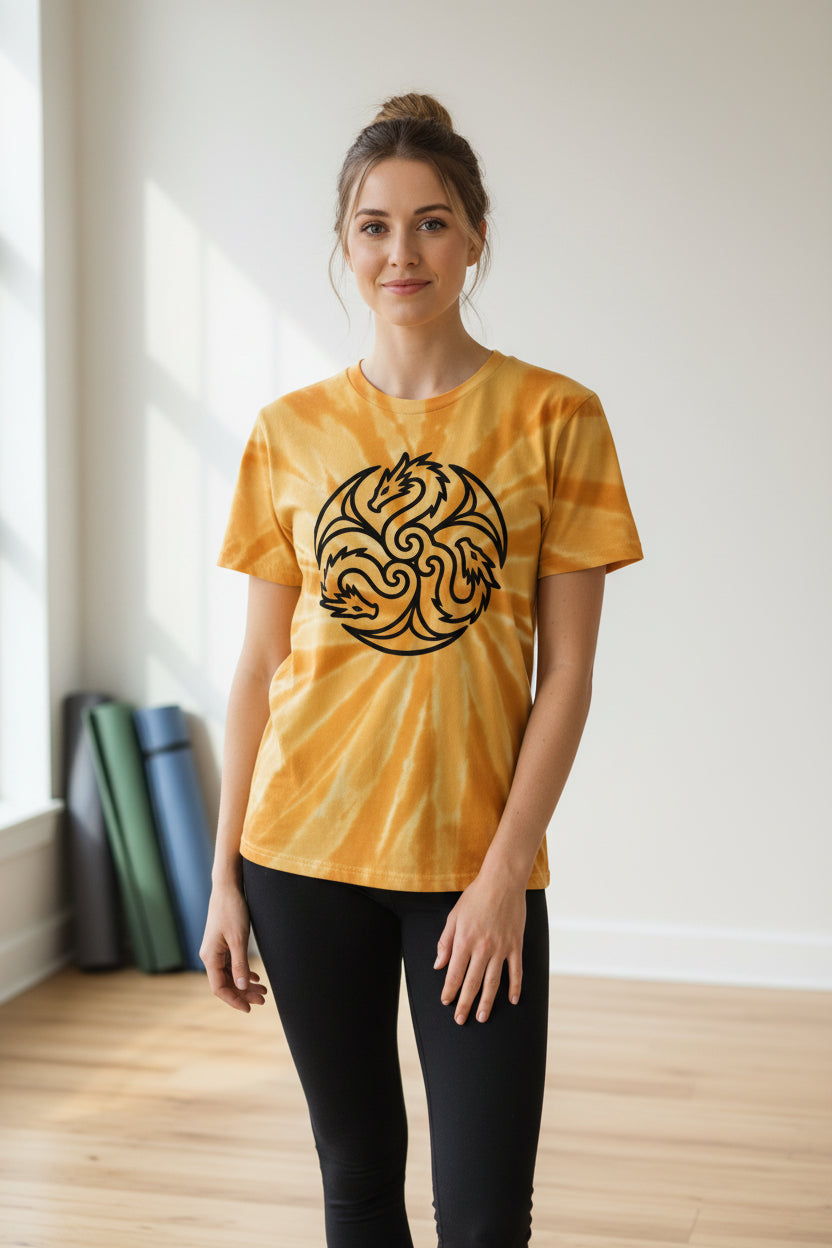 A short-sleeve crewneck t-shirt with a yellow and orange sunburst tie-dye pattern, featuring a black circular triple dragon graphic printed on the chest.