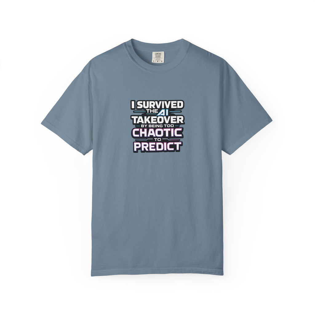 A blue short-sleeve t-shirt with a graphic text print on the chest that reads 'I SURVIVED THE  AI TAKEOVER BY BEING TOO CHAOTIC OR PREDICT'. The shirt is displayed flat against a clean white background.