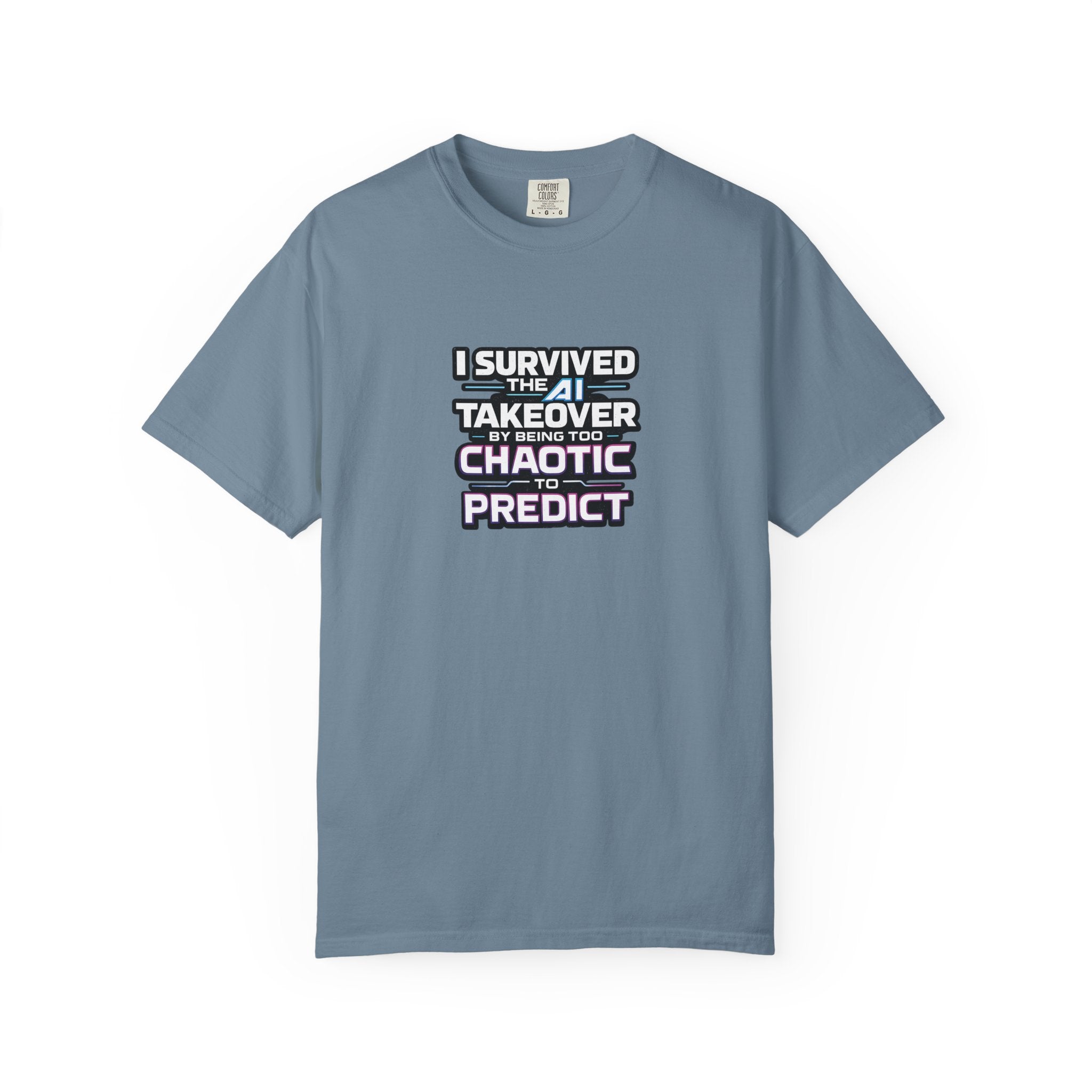 A blue short-sleeve t-shirt with a graphic text print on the chest that reads 'I SURVIVED THE  AI TAKEOVER BY BEING TOO CHAOTIC OR PREDICT'. The shirt is displayed flat against a clean white background.