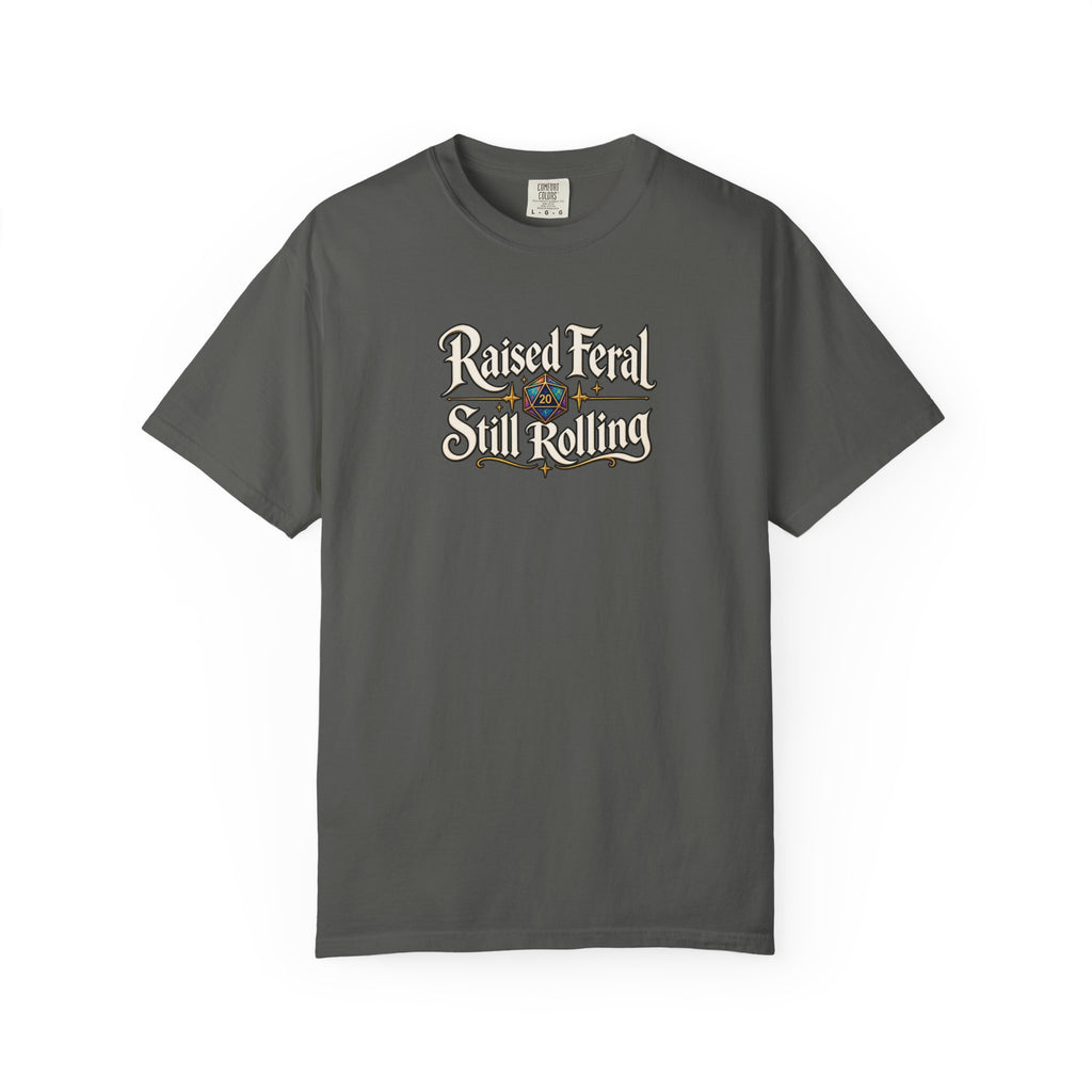 A gray graphic T-shirt  that features the text 'Raised Feral Still Rolling' with a colorful 20-sided die graphic in the center against a white background