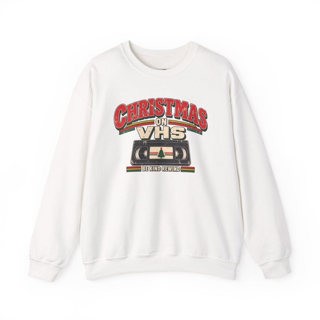 A beige crewneck sweatshirt featuring a retro VHS graphic with the text 'CHRISTMAS ON VHS' and 'BE KIND REWIND' on a white background.