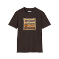 A Brown  short-sleeve crewneck t-shirt featuring a colorful graphic on the chest that reads 'SIDE QUEST TO ACQUIRE CANDY REWARD: MORE CANDY' with a jack-o'-lantern illustration.