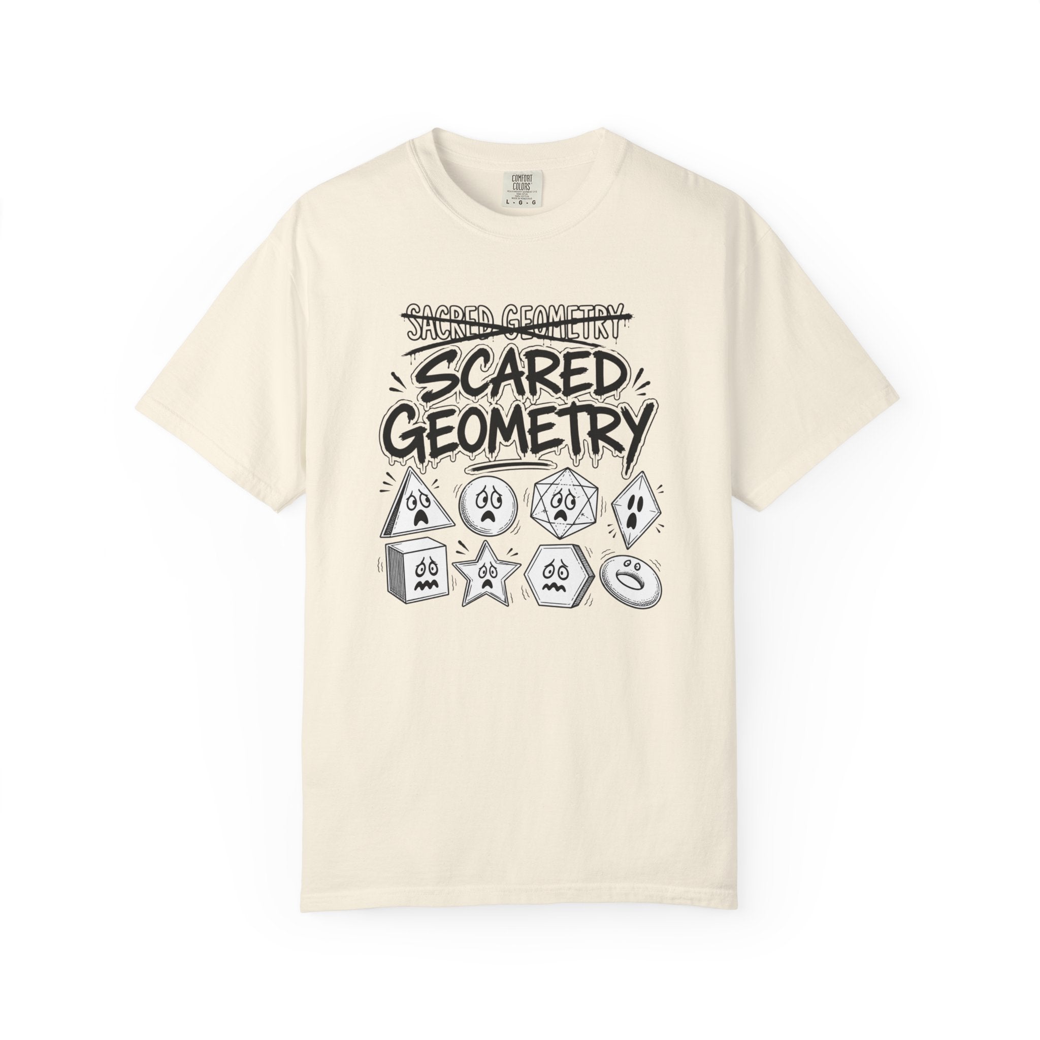 An off-white short-sleeve t-shirt with a black and gray graphic print on the front that reads 'SCARED GEOMETRY' above and below a collection of cartoonish gaming dice.
