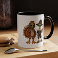 A white ceramic coffee mug with a black interior and handle, featuring a cartoon graphic of a turkey and a pilgrim holding a 'Mug Shot' mug. The mug is set on a wooden board with a spoon and coffee beans in the background