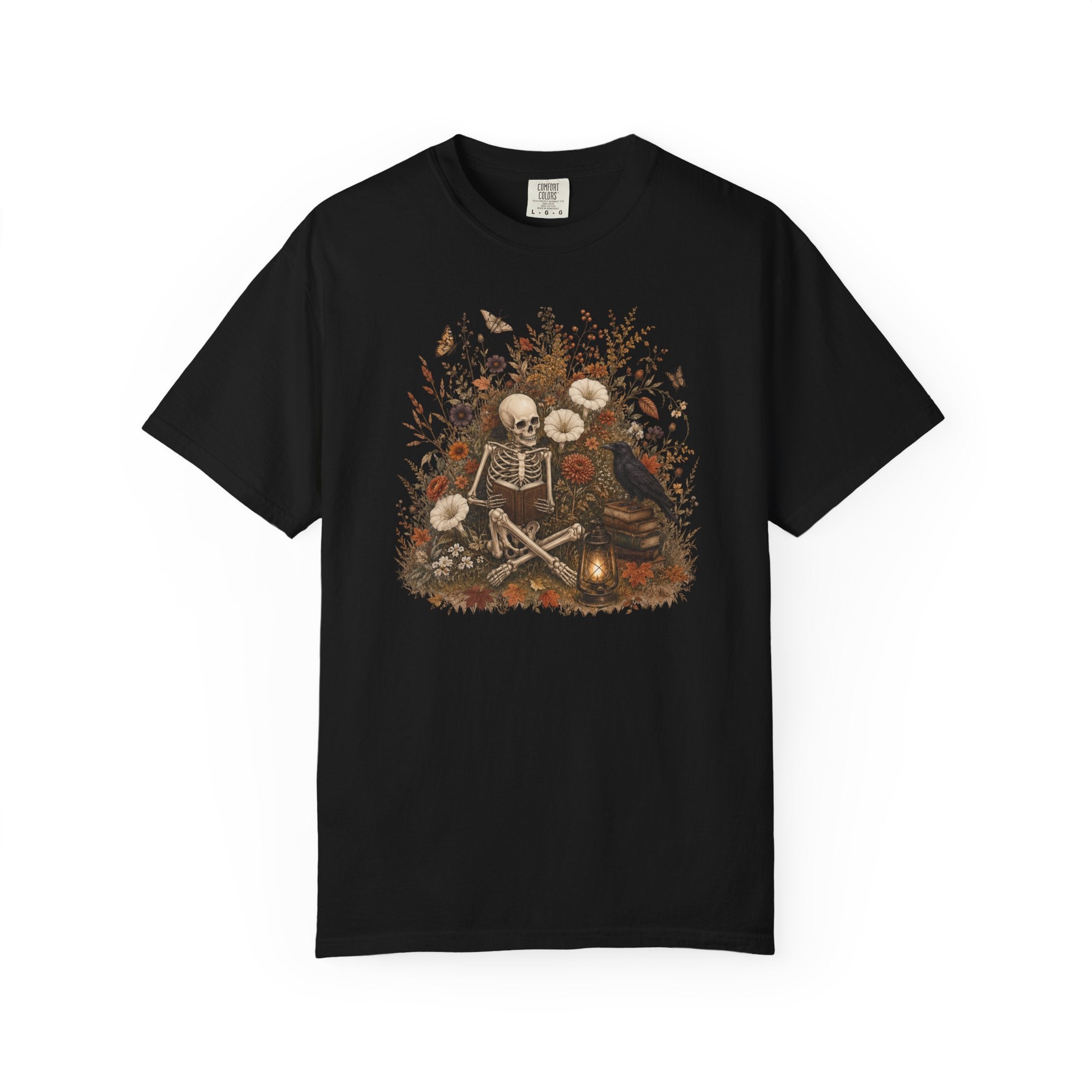 A black short-sleeve crewneck t-shirt featuring a detailed graphic print of a skeleton sitting next to a raven by a campfire, surrounded by autumn leaves and flowers.
