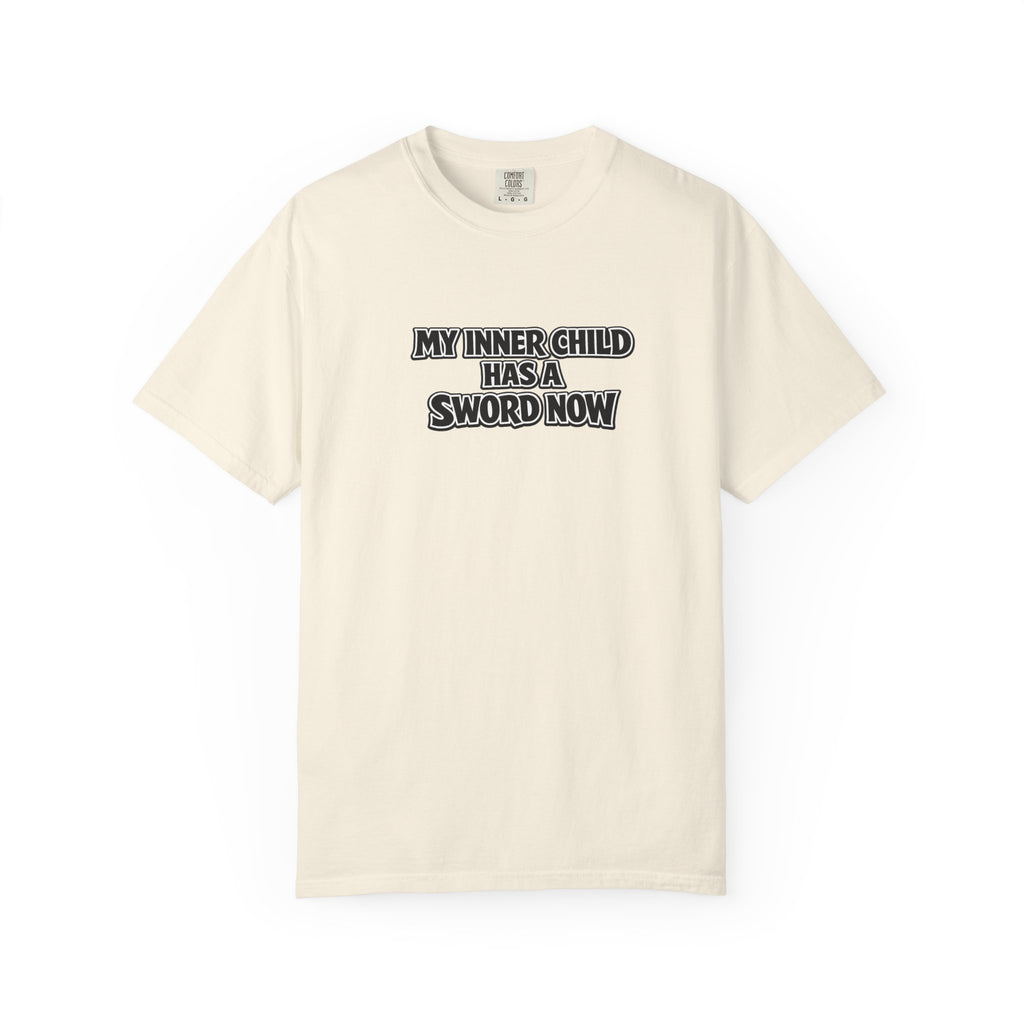An off-white short-sleeve crewneck t-shirt with the text 'MY INNER-CHILD HAS A SWORD NOW' printed in black and white block letters across the chest, displayed on a clean white background.
