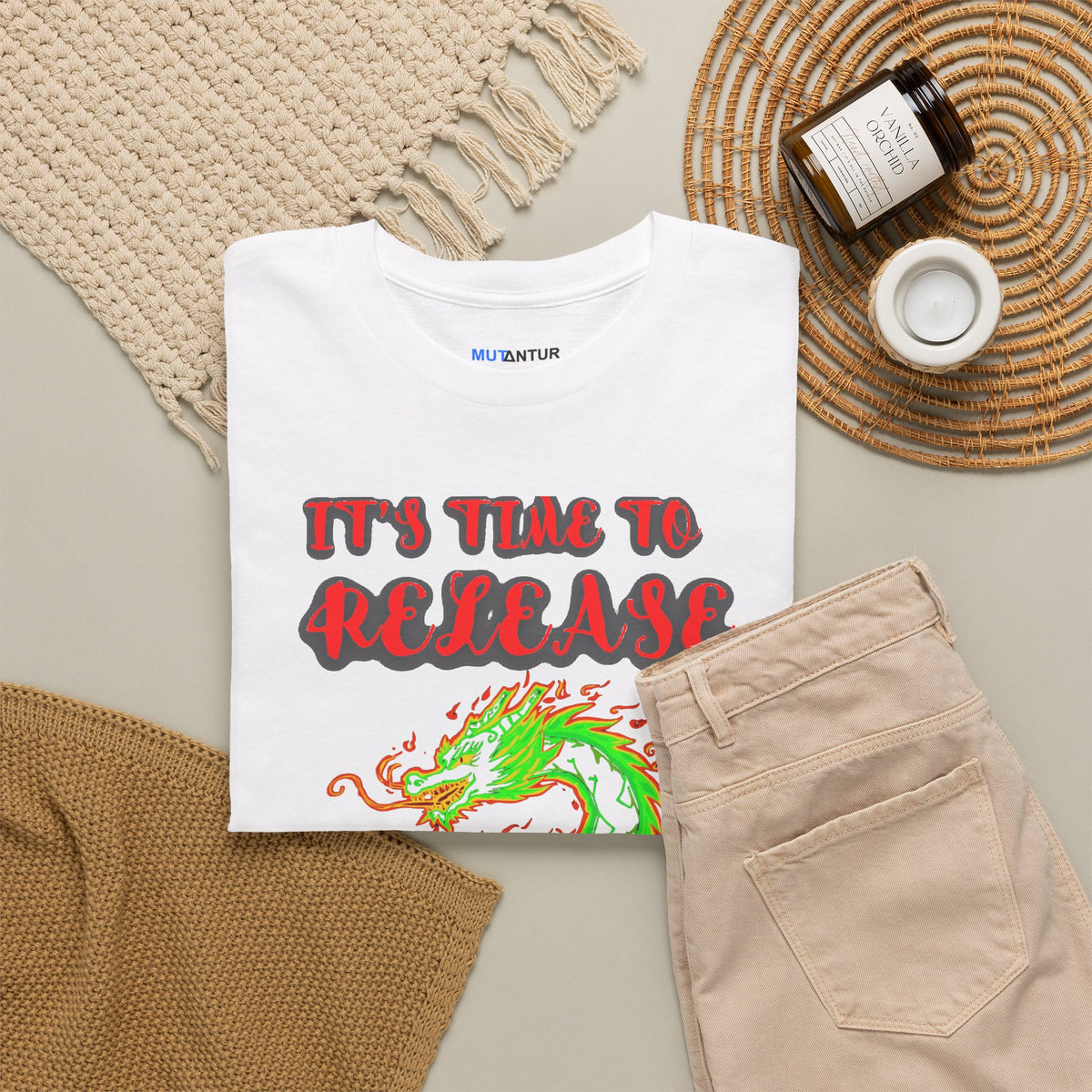 It's Time to Release the Dragon green fire dragon graphic t-shirt in white, folded flat lay styled with a knit blanket and jar