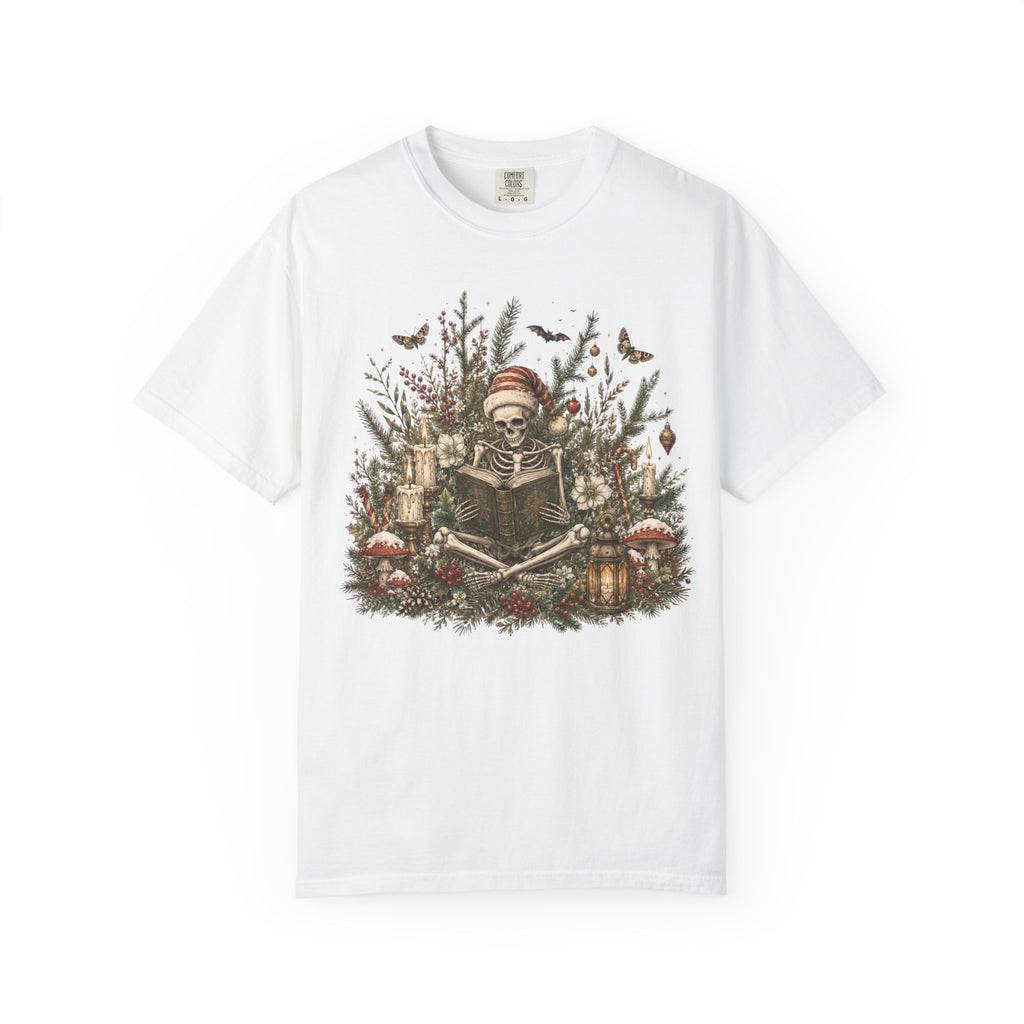 A white short-sleeve crewneck t-shirt featuring a detailed graphic print of a skeleton wearing a Santa hat, surrounded by Christmas trees, candles, and mushrooms.
