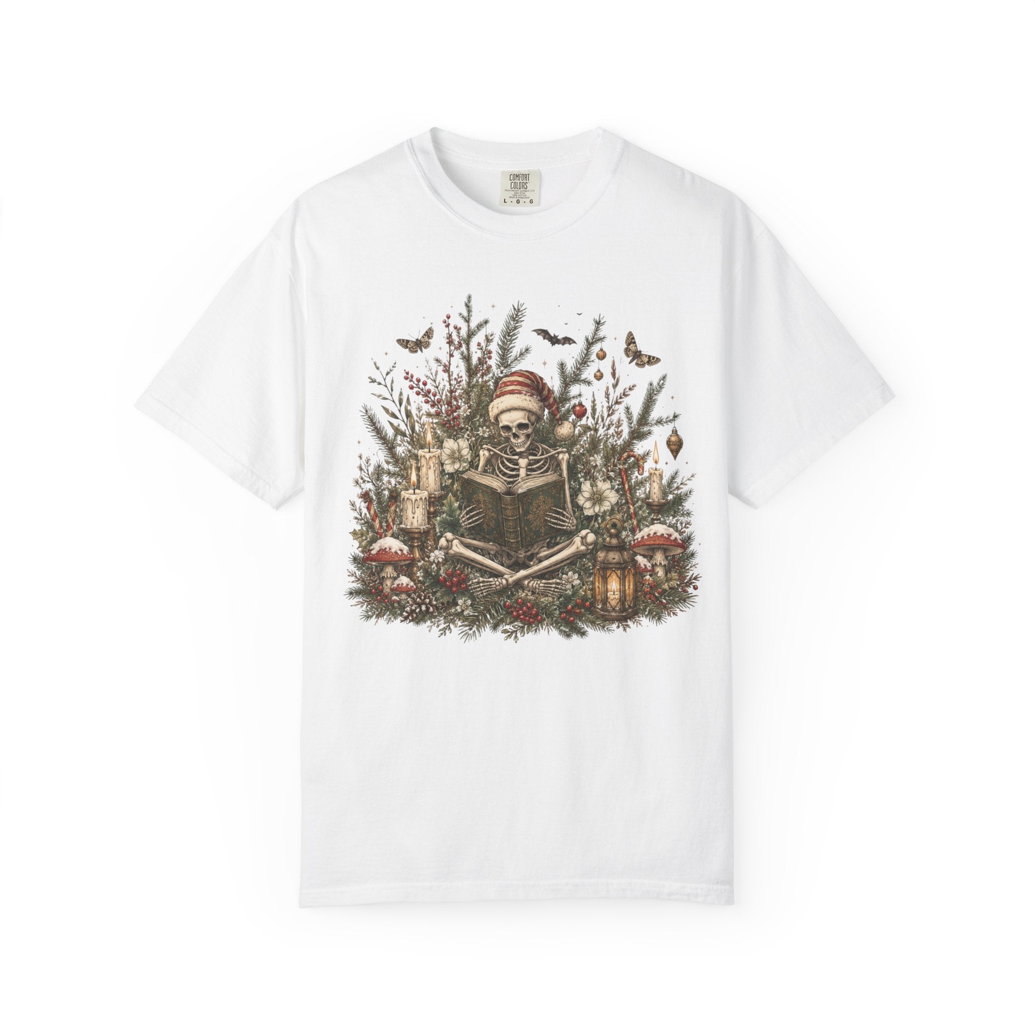 A white short-sleeve crewneck t-shirt featuring a detailed graphic print of a skeleton wearing a Santa hat, surrounded by Christmas trees, candles, and mushrooms.