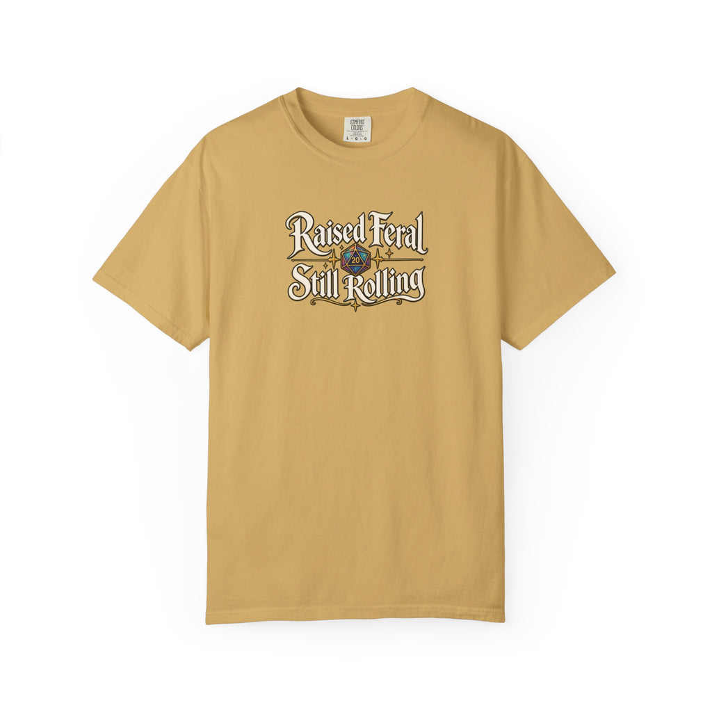A mustard yellow graphic T-shirt  that features the text 'Raised Feral Still Rolling' with a colorful 20-sided die graphic in the center against a white background