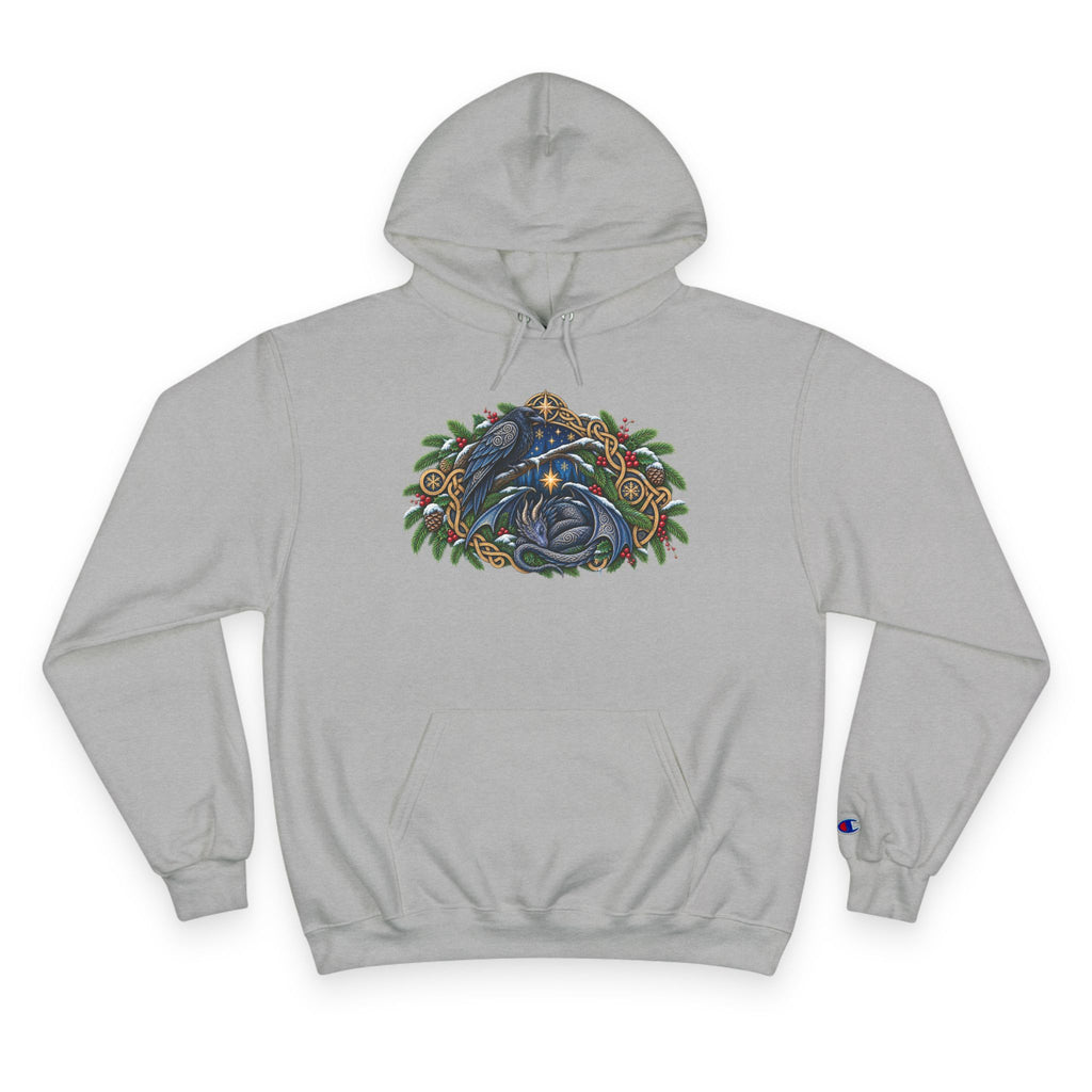 A light gray pullover hoodie featuring a detailed graphic of a blue raven and a dragon surrounded by green pine boughs  A small blue Champion 'C' logo is visible on the left sleeve cuff. against a white background