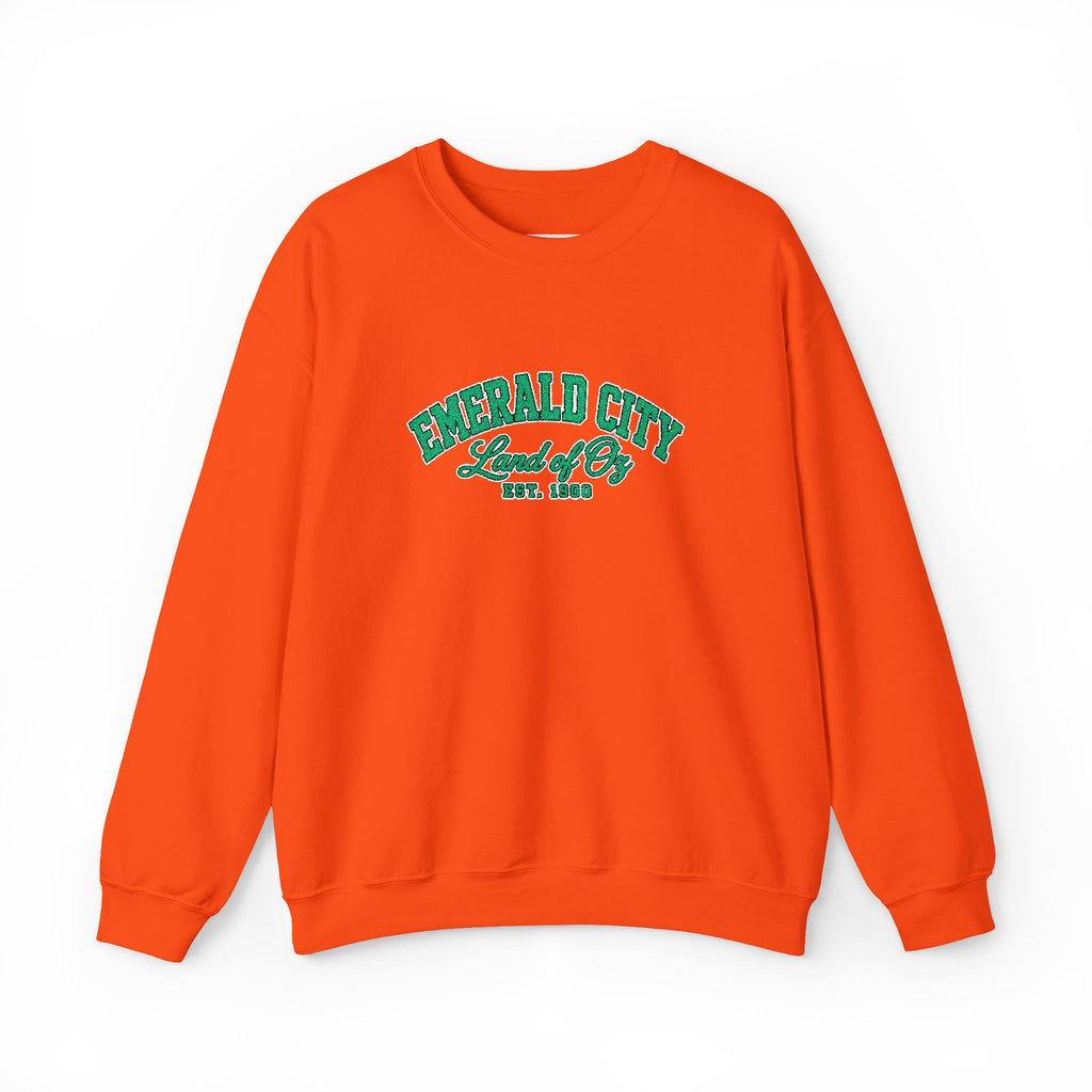 A bright orange crewneck sweatshirt with 'EMERALD CITY Land of Oz EST. 1900' printed in green on the chest, displayed against a plain white background.