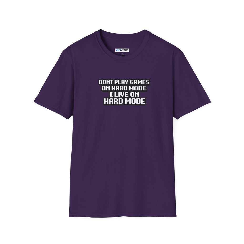A purple short-sleeve t-shirt with a white and black text graphic on the chest that reads 'DONT PLAY GAMES ON HARD MODE I LIVE ON HARD MODE'. The shirt is displayed flat against a solid white background.