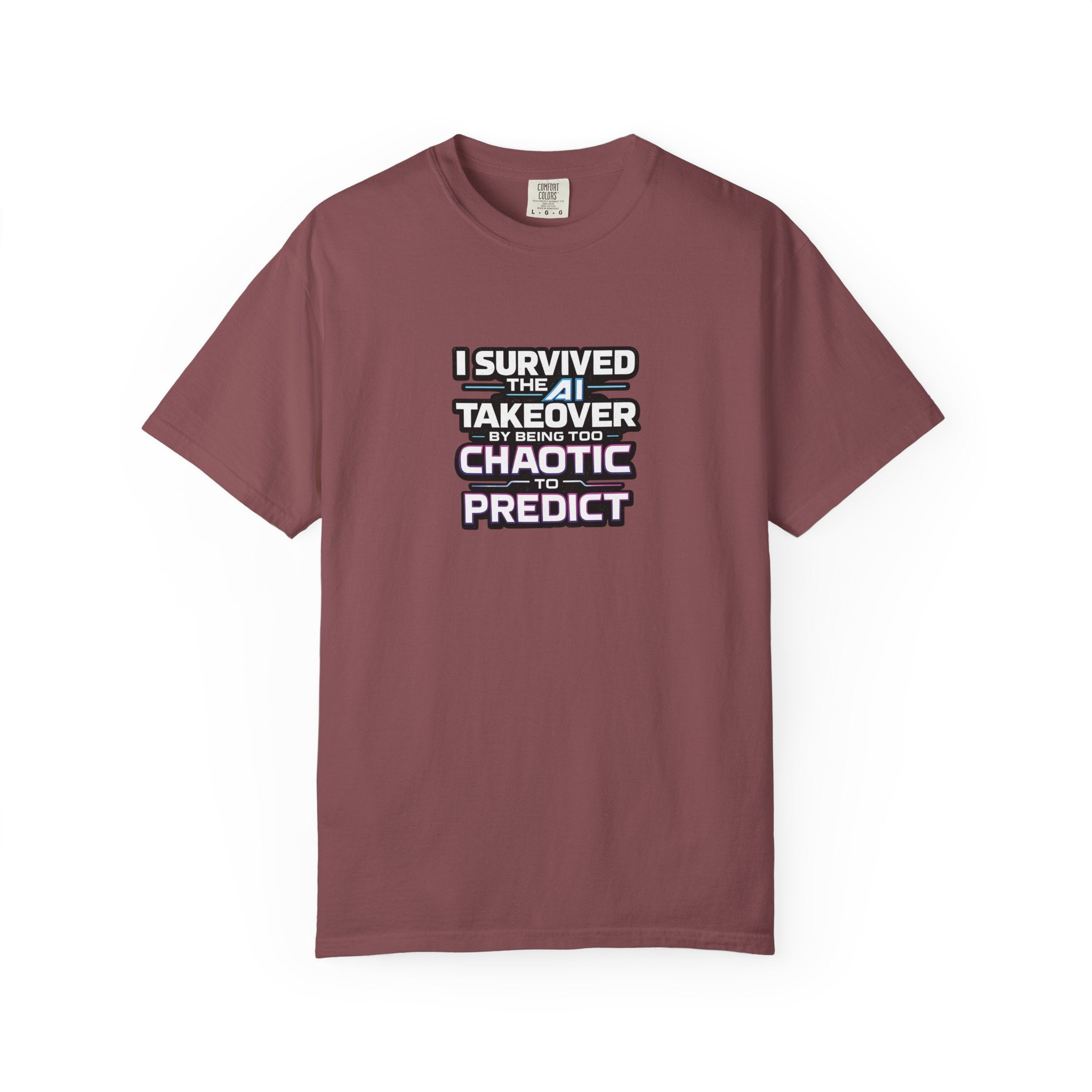 A mauve short-sleeve crewneck t-shirt with a graphic text print on the chest that reads 'I SURVIVED THE AI TAKEOVER BY BEING TOO CHAOTIC TO PREDICT'.