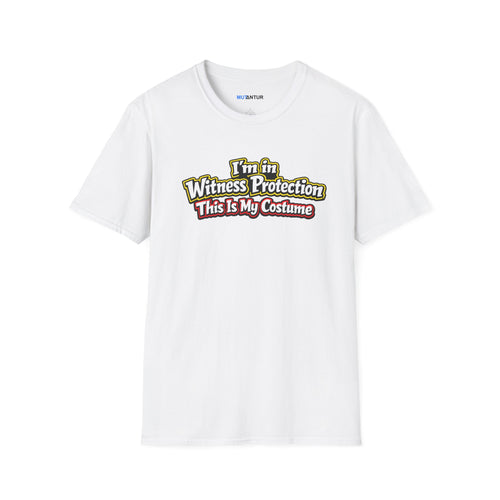 A white short-sleeve crewneck t-shirt featuring a graphic on the chest that reads 'I'm in Witness Protection This Is My Costume' in a stylized, vintage font with green, yellow, and red accents
