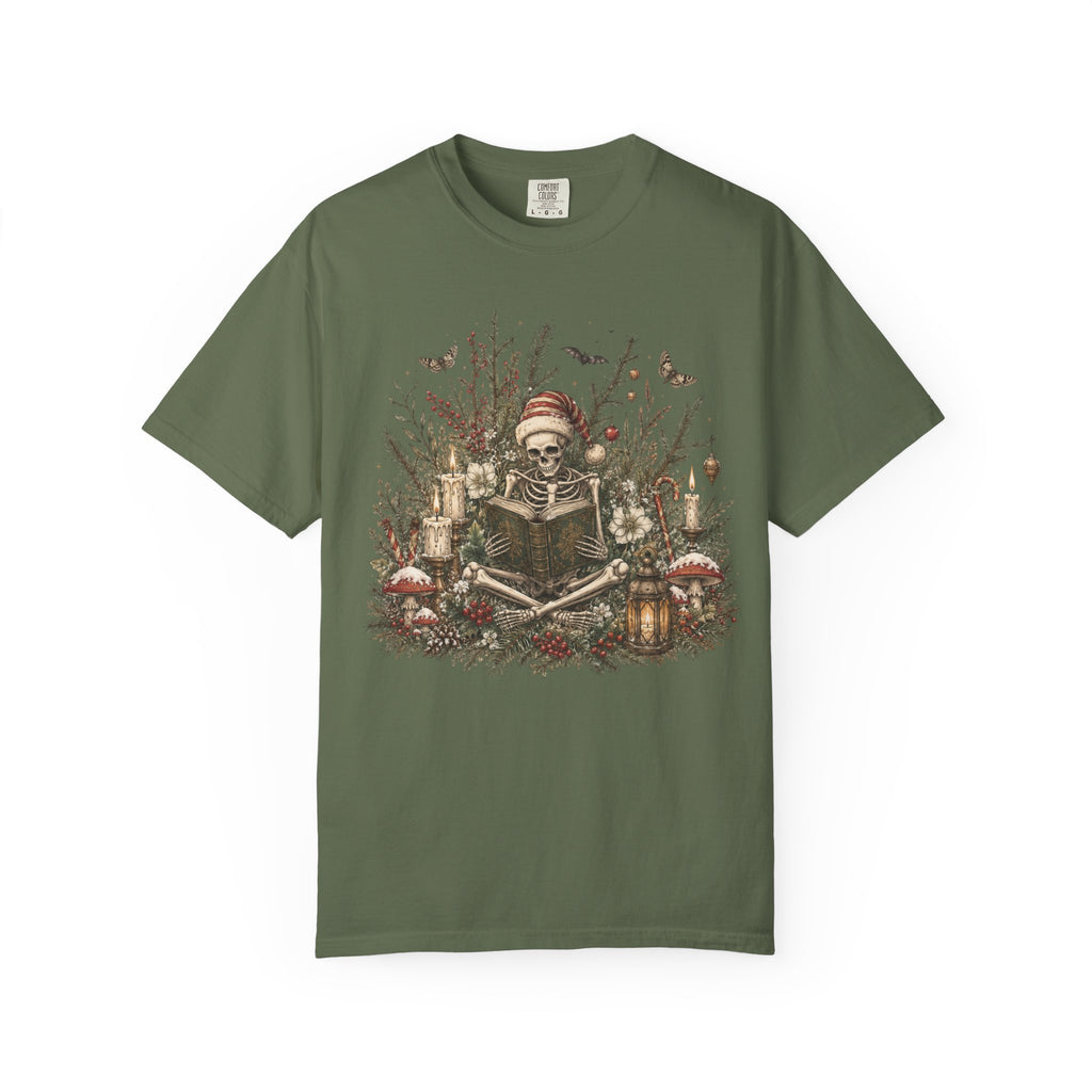 A green short-sleeve crewneck t-shirt featuring a detailed graphic print of a skeleton wearing a Santa hat, surrounded by Christmas trees, candles, and mushrooms.