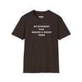 An brown short-sleeve crewneck t-shirt with black printed text on the chest reading 'MY RETIREMENT PLAN INVOLVES A WIZARD TOWER'.