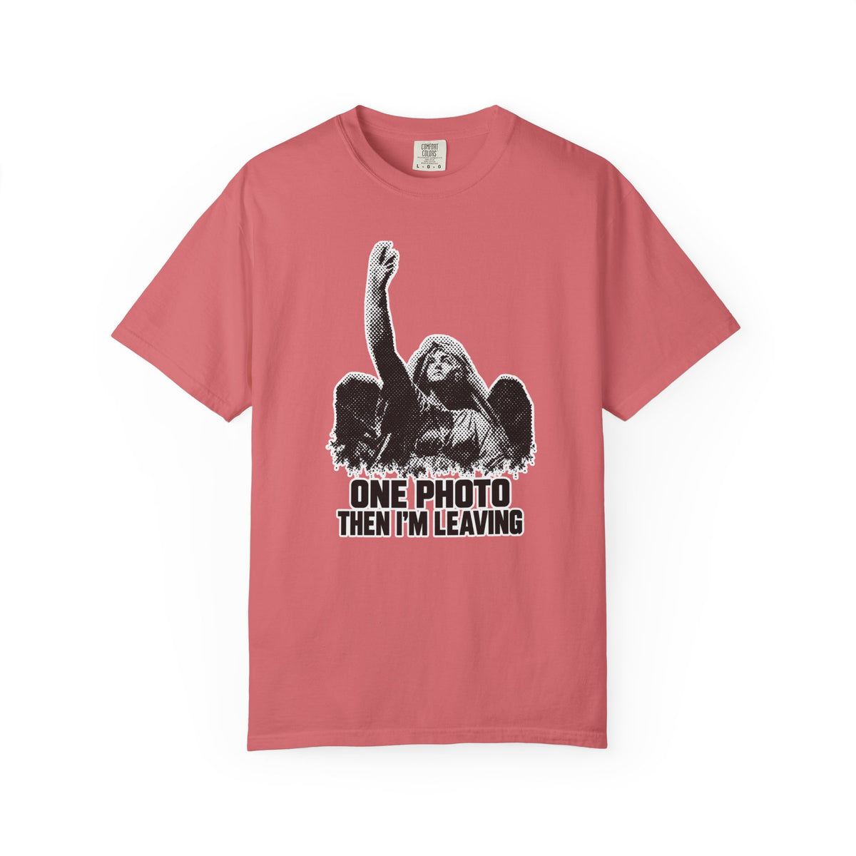 A pink short-sleeve crewneck t-shirt featuring a black and white graphic of a winged angel with a raised hand, above the text 'ONE PHOTO THEN I'M LEAVING' in black block letters.