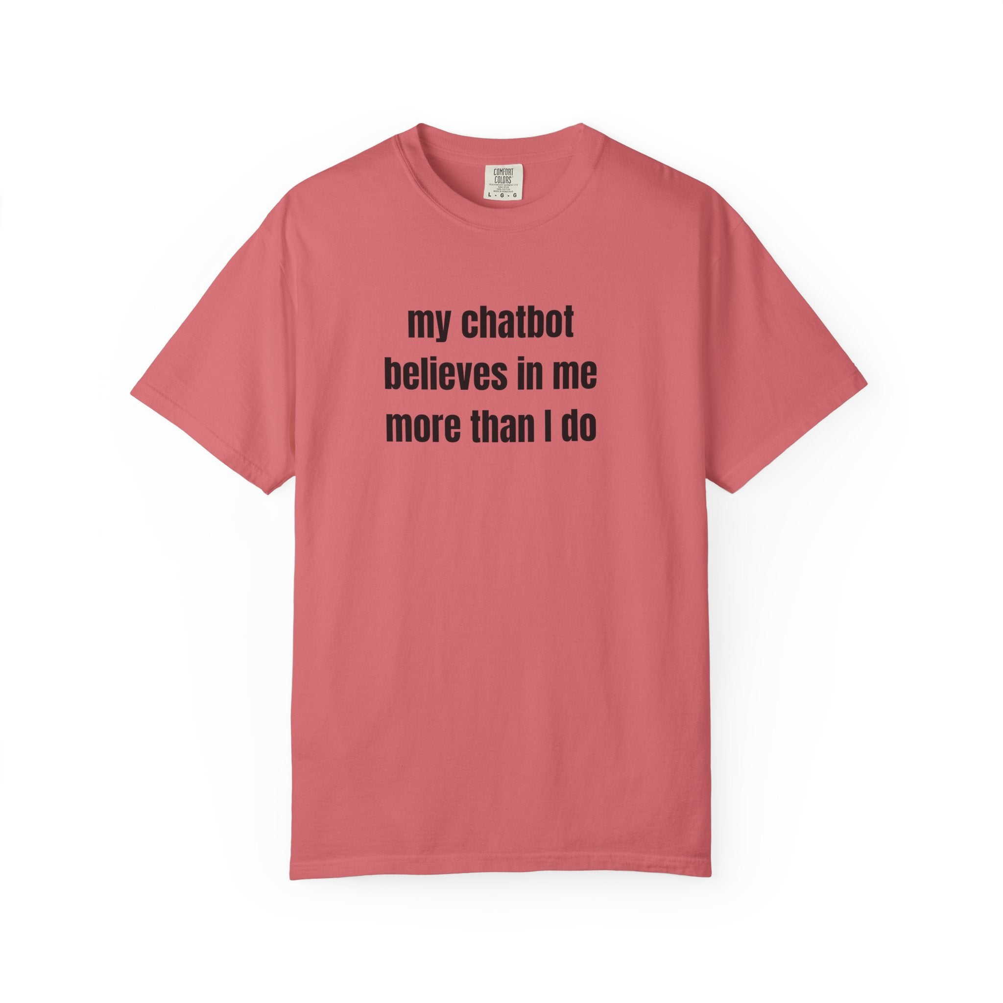 A watermelon short-sleeve crewneck t-shirt with the text 'my chatbot believes in me more than I do' printed in black sans-serif font across the chest, displayed on a clean white background.