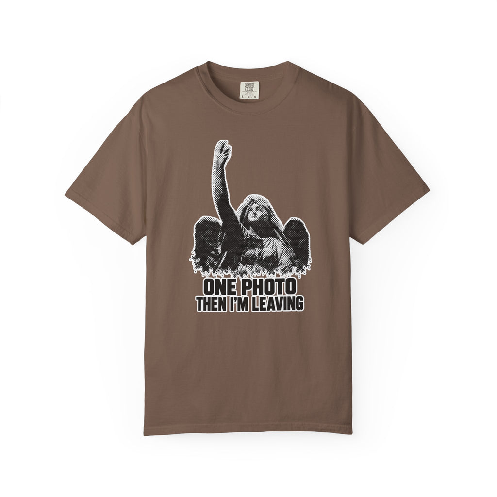 A brown short-sleeve crewneck t-shirt with a black and white graphic of a winged angel raising its hand, above the text 'ONE PHOTO THEN I'M LEAVING'.