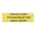 A rectangular yellow sign or sticker with black gothic-style text reading 'I'M NOT LOST I'M IGNORING THE MAIN QUEST' on a plain white background.