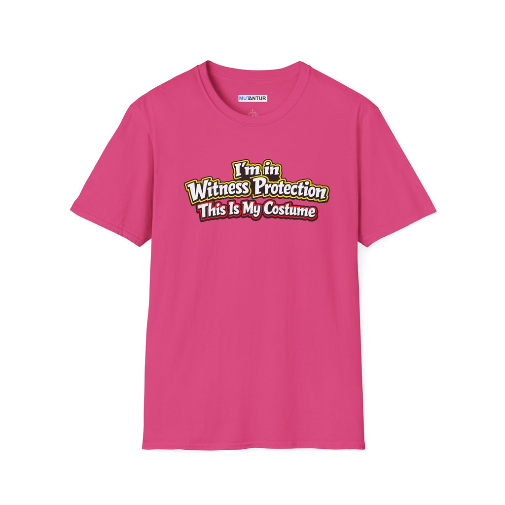 Pink short-sleeve crewneck t-shirt featuring a graphic on the chest that reads 'I'm in Witness Protection This Is My Costume' in a stylized, vintage font with green, yellow, and red accents