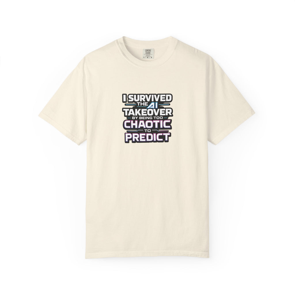 A beige short-sleeve crewneck t-shirt with a graphic text print on the chest that reads 'I SURVIVED THE AI TAKEOVER BY BEING TOO CHAOTIC TO PREDICT'.