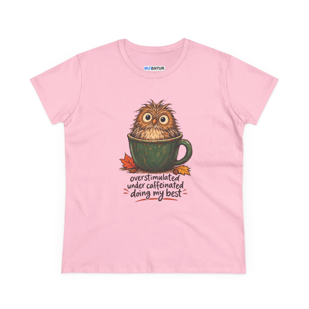 A light pink short-sleeve t-shirt with a graphic of a cute, fluffy brown owl sitting inside a green coffee mug, with the text 'overstimulated under caffeinated doing my best' written below. 