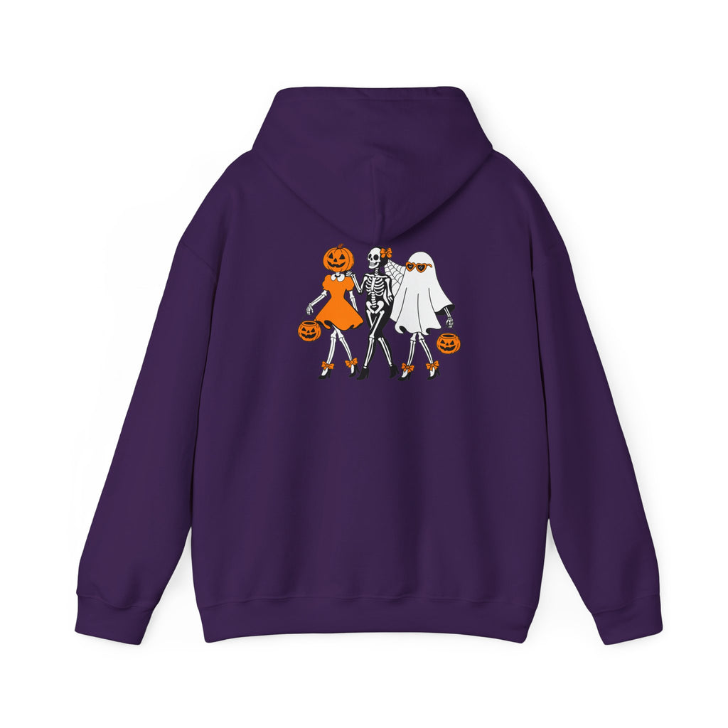 A purple hoodie shown from the back, featuring a graphic print of three Halloween characters: a pumpkin-headed girl in orange, a skeleton in black and white, and a ghost character in white holding a pumpkin.