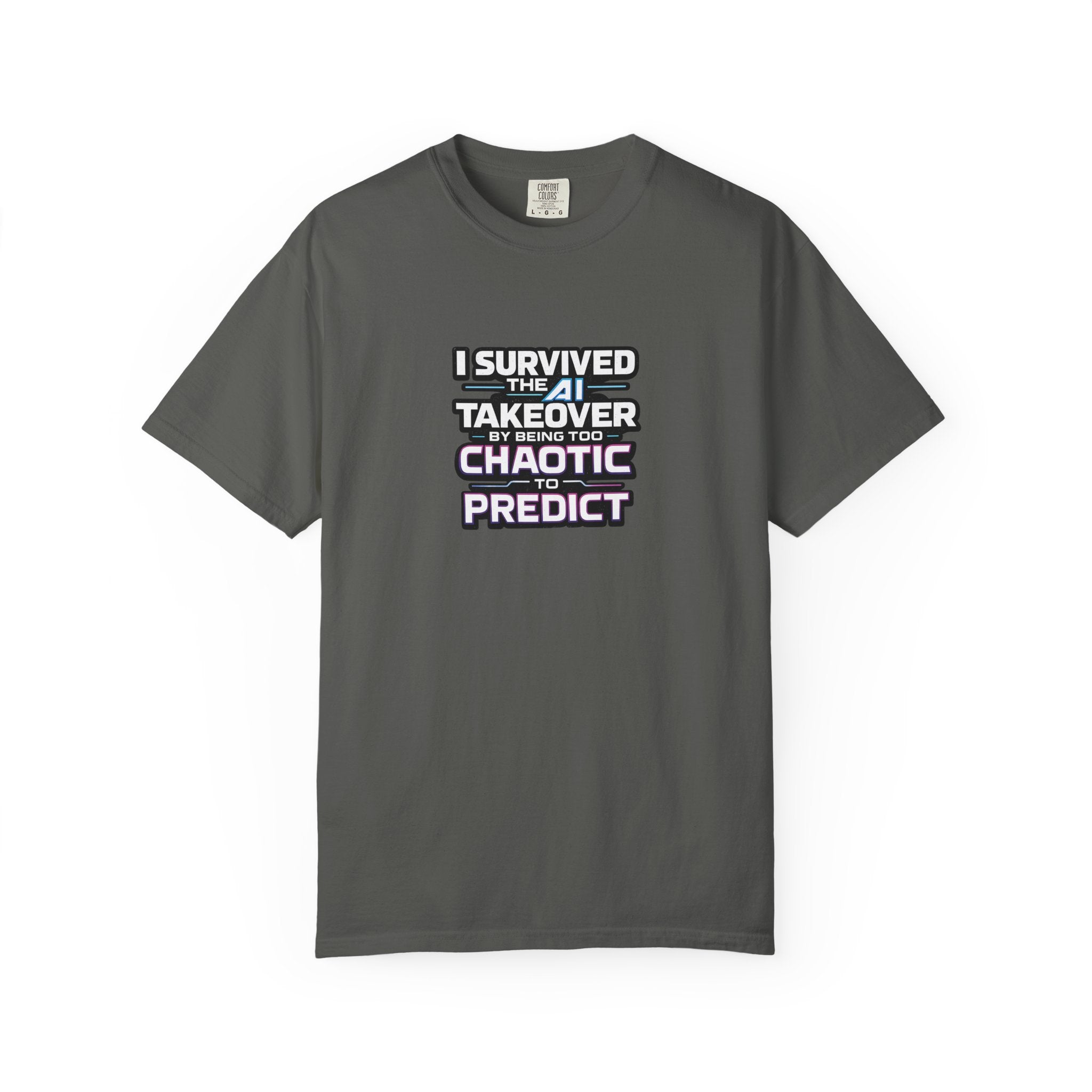 A grey short-sleeve t-shirt with a graphic text print on the chest that reads 'I SURVIVED THE AI TAKEOVER BY BEING TOO CHAOTIC TO PREDICT'. The shirt is displayed flat against a clean white background.