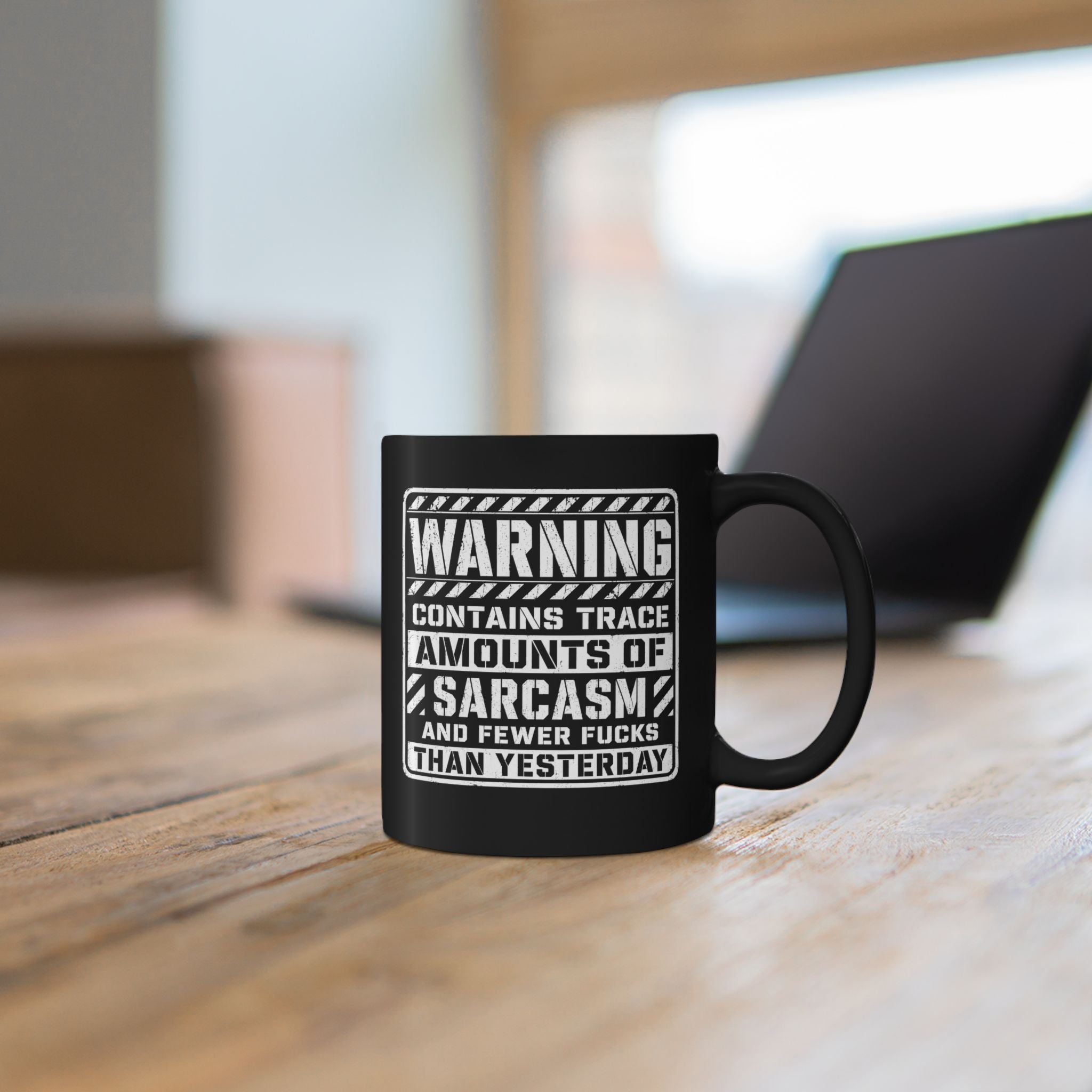 Black ceramic coffee mug printed with the warning label "Contains Trace Amounts of Sarcasm."