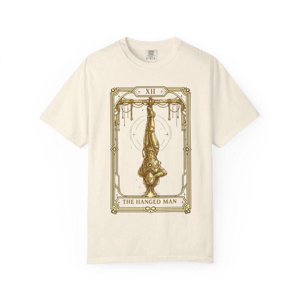 a beige t-shirt featuring The Hanged Man from the Future Arcana collection, inspired by The Hanged Man tarot card. A futuristic explorer hangs suspended upside down within an elegant Art Deco celestial frame, illustrated in vintage gold line art on a transparent background.